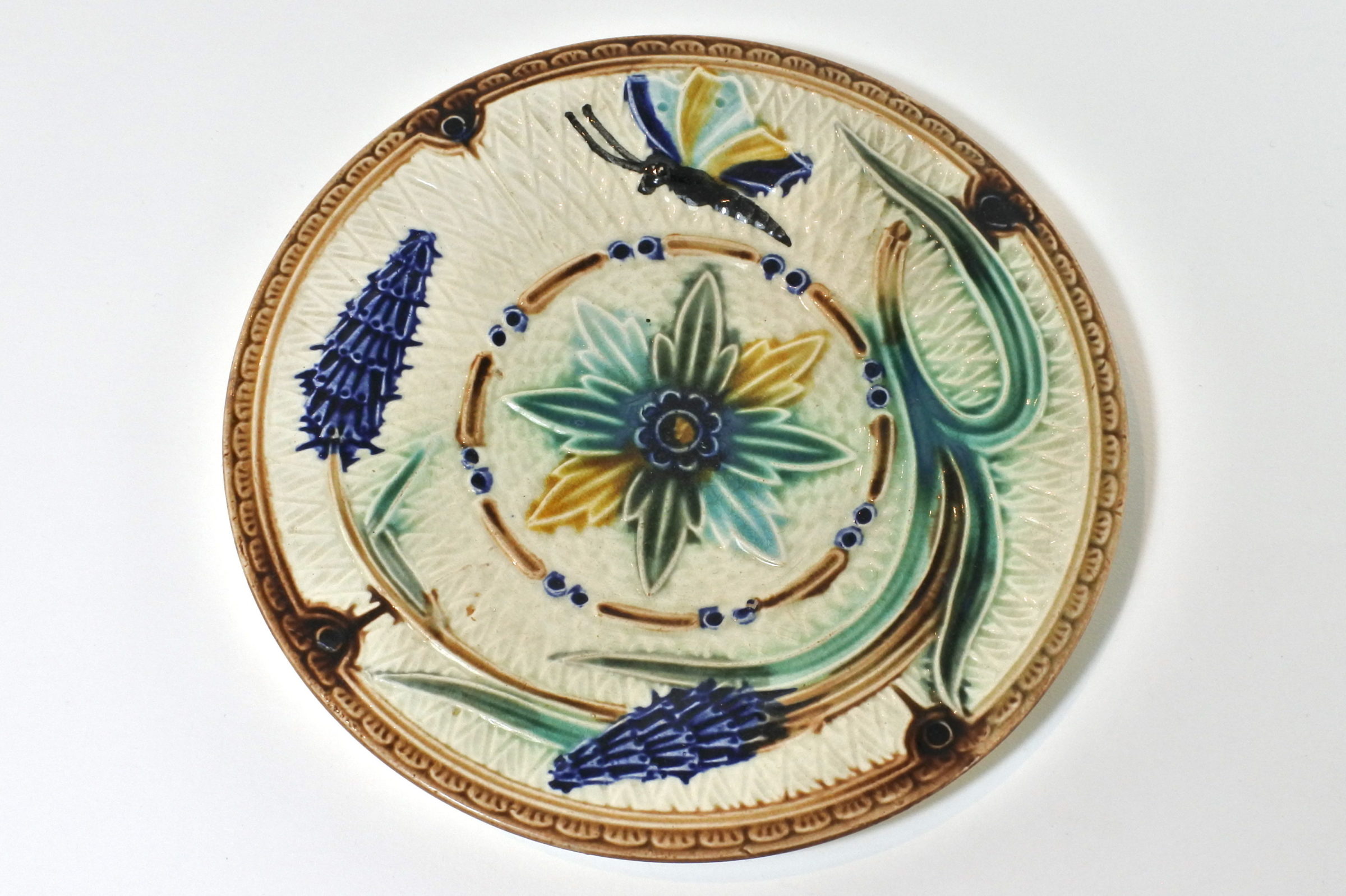 Piatto in ceramica barbotine con fiori e farfalla
