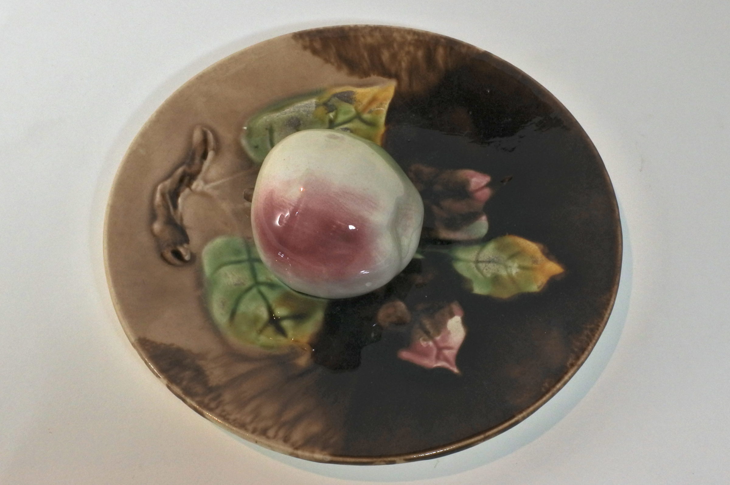 Piatto in ceramica barbotine con mela in rilievo