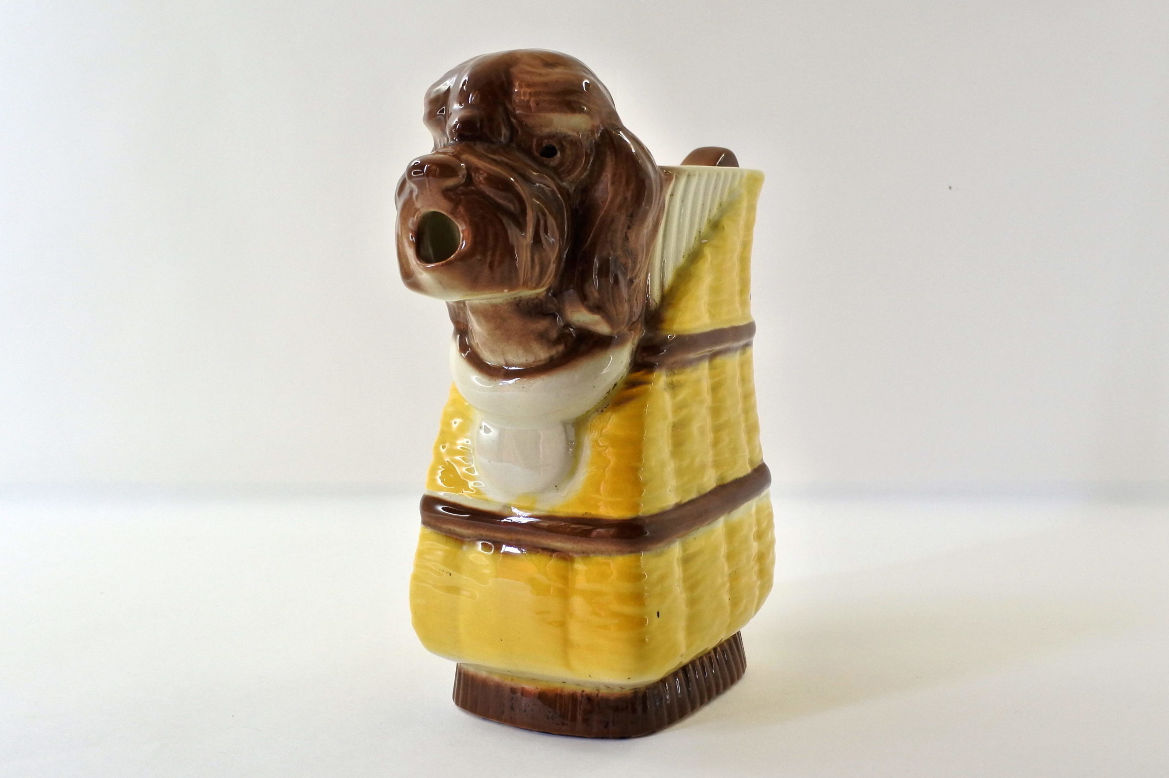 Brocca in ceramica barbotine a forma di cane che esce dal cestino