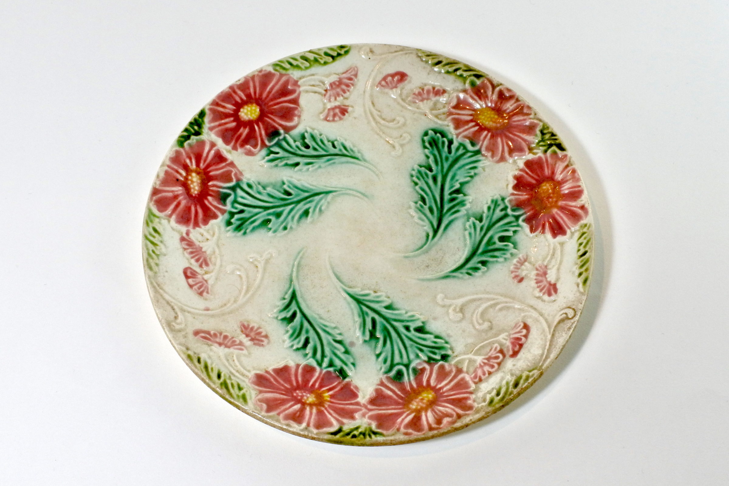 Piatto in ceramica barbotine con margherite rosse