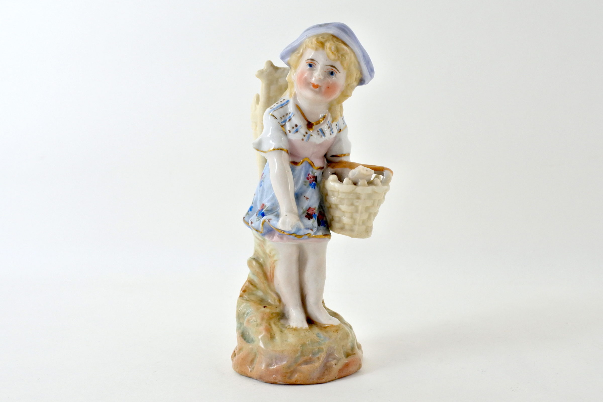 Statuina in ceramica a forma di bambina con gerla