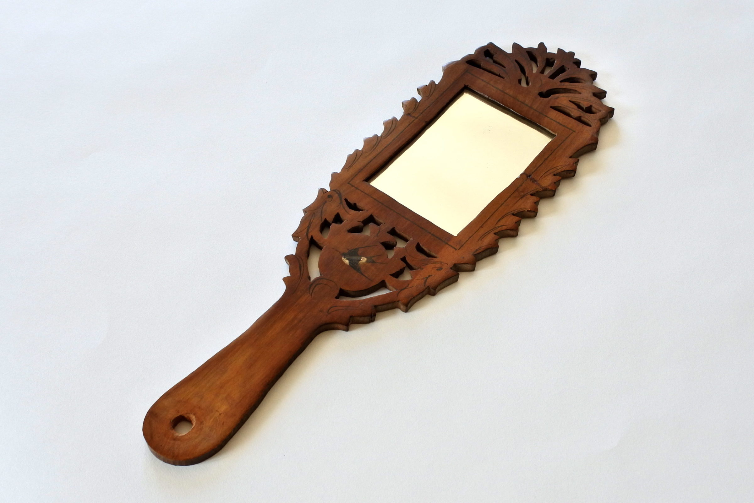 Specchietto in legno d’ulivo traforato e decorato con rondine