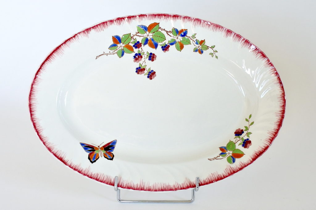 Piatto ovale in ceramica di Longwy con farfalla e rami di more