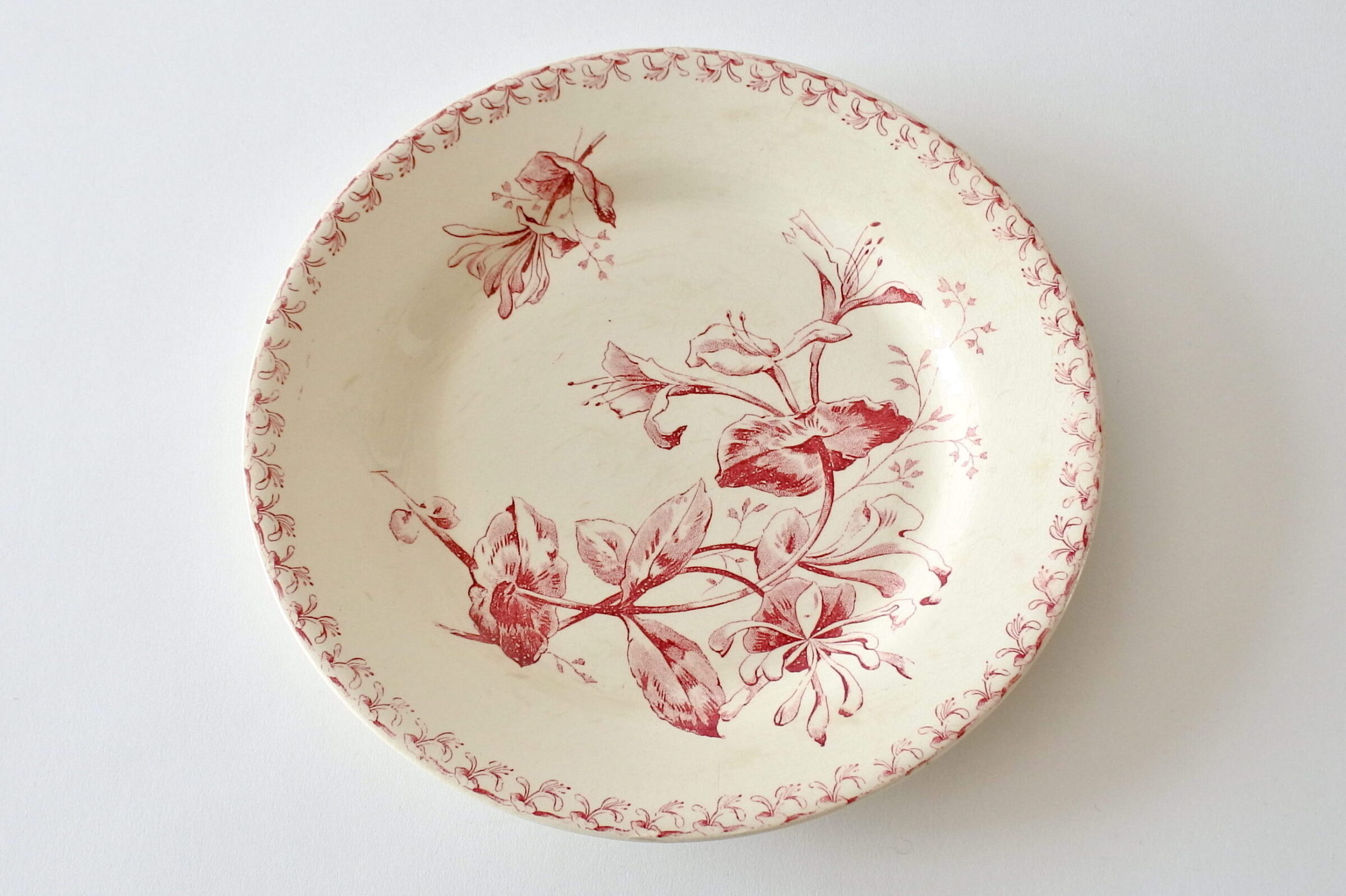 Piatto in ceramica di Gien del 1878 con decoro di caprifogli rossi