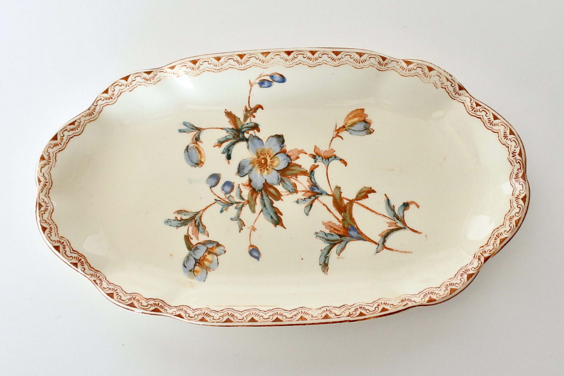 Raviera in ceramica di Salins decorata con greca e rami di fiori blu e marroni