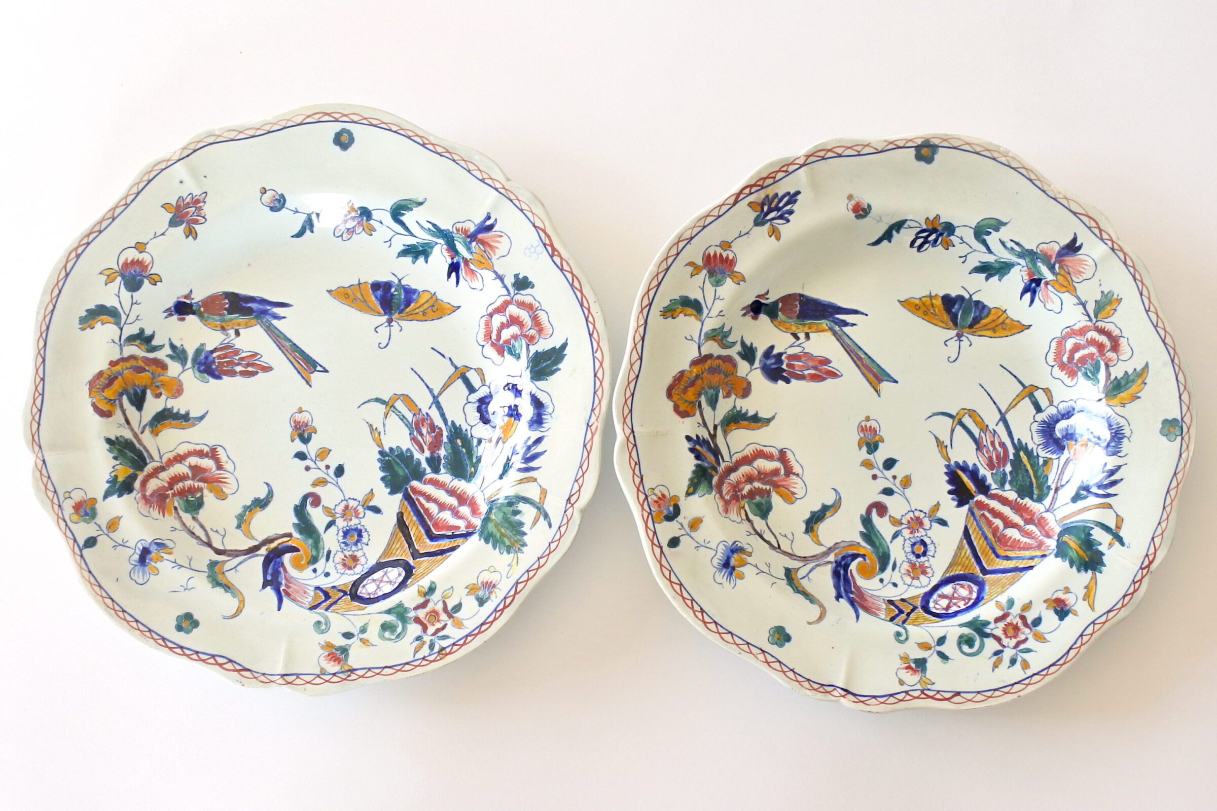 Coppia di piatti fondi in ceramica di Gien con cornucopia farfalla fiori ed uccello
