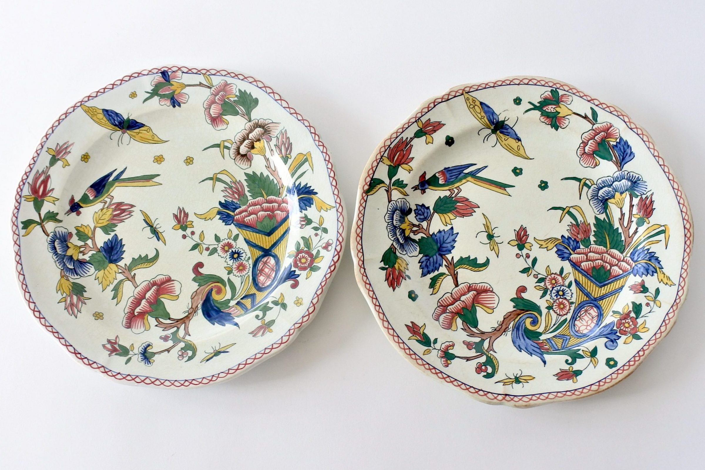 Coppia di piatti piani in ceramica di Gien con cornucopia farfalla fiori ed uccello