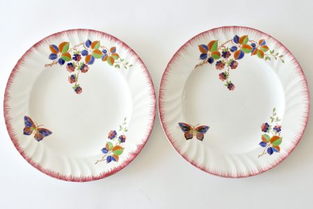 Coppia di piatti piani in ceramica di Longwy con farfalla e rami di more